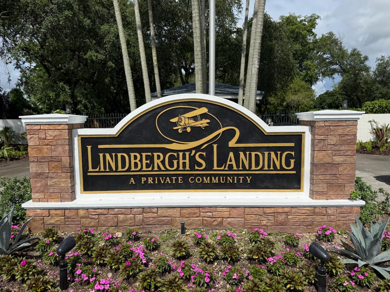 Lindbergh’s Landing entrance monument with biplane emblem and flowering landscaping